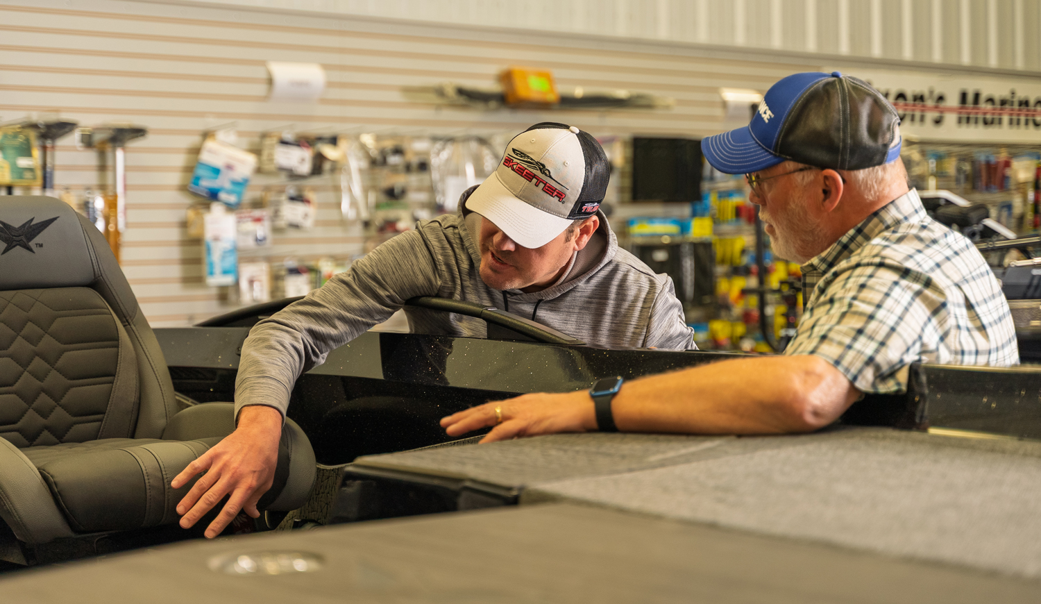 Two men inspecting a boat's interior.
