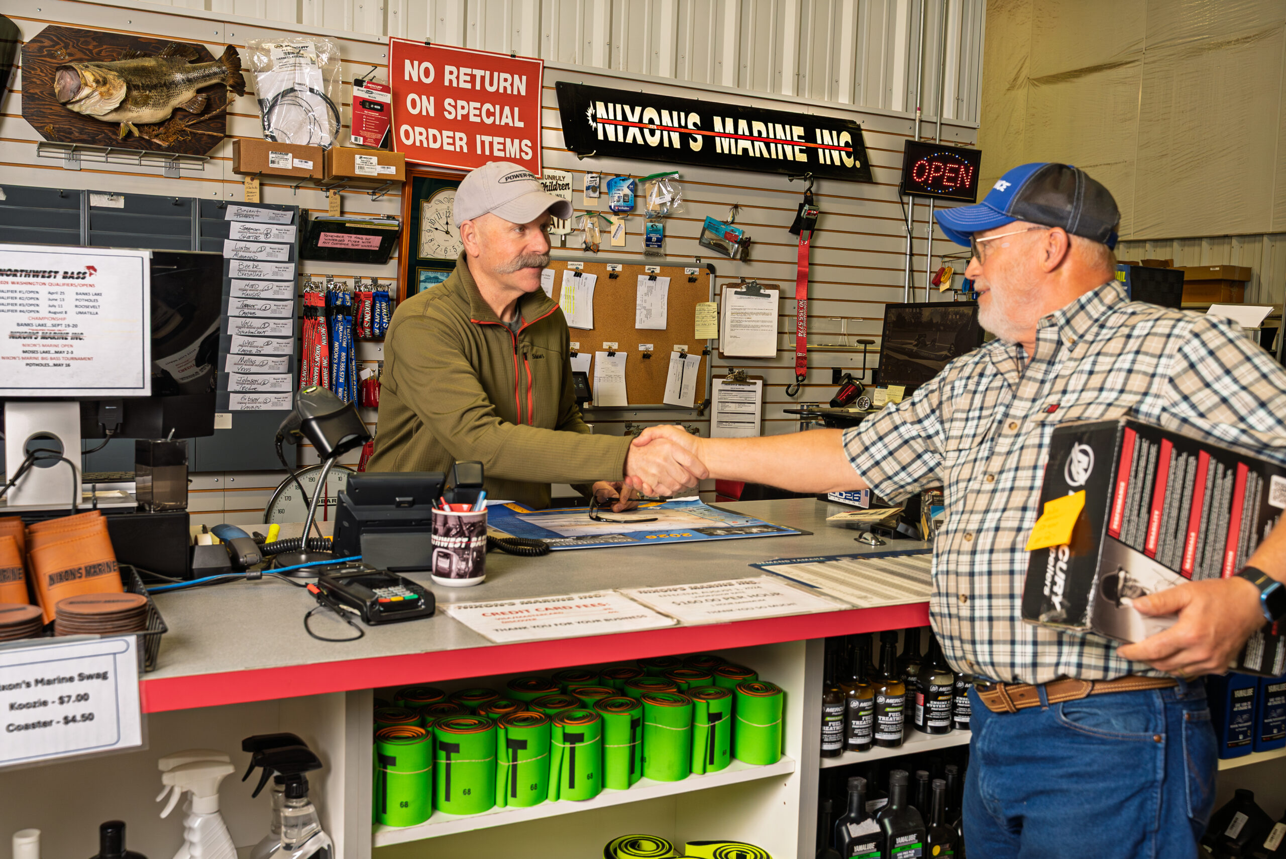Two men shaking hands at a store counter