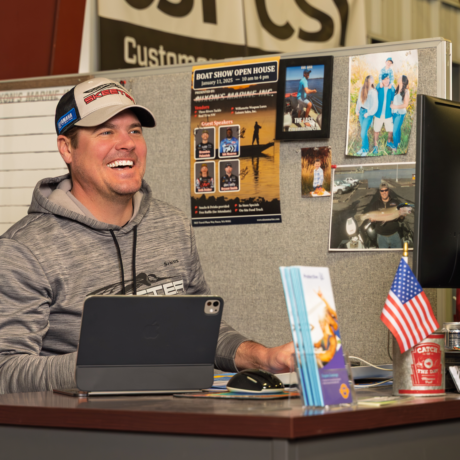 Smiling man at desk with fishing posters