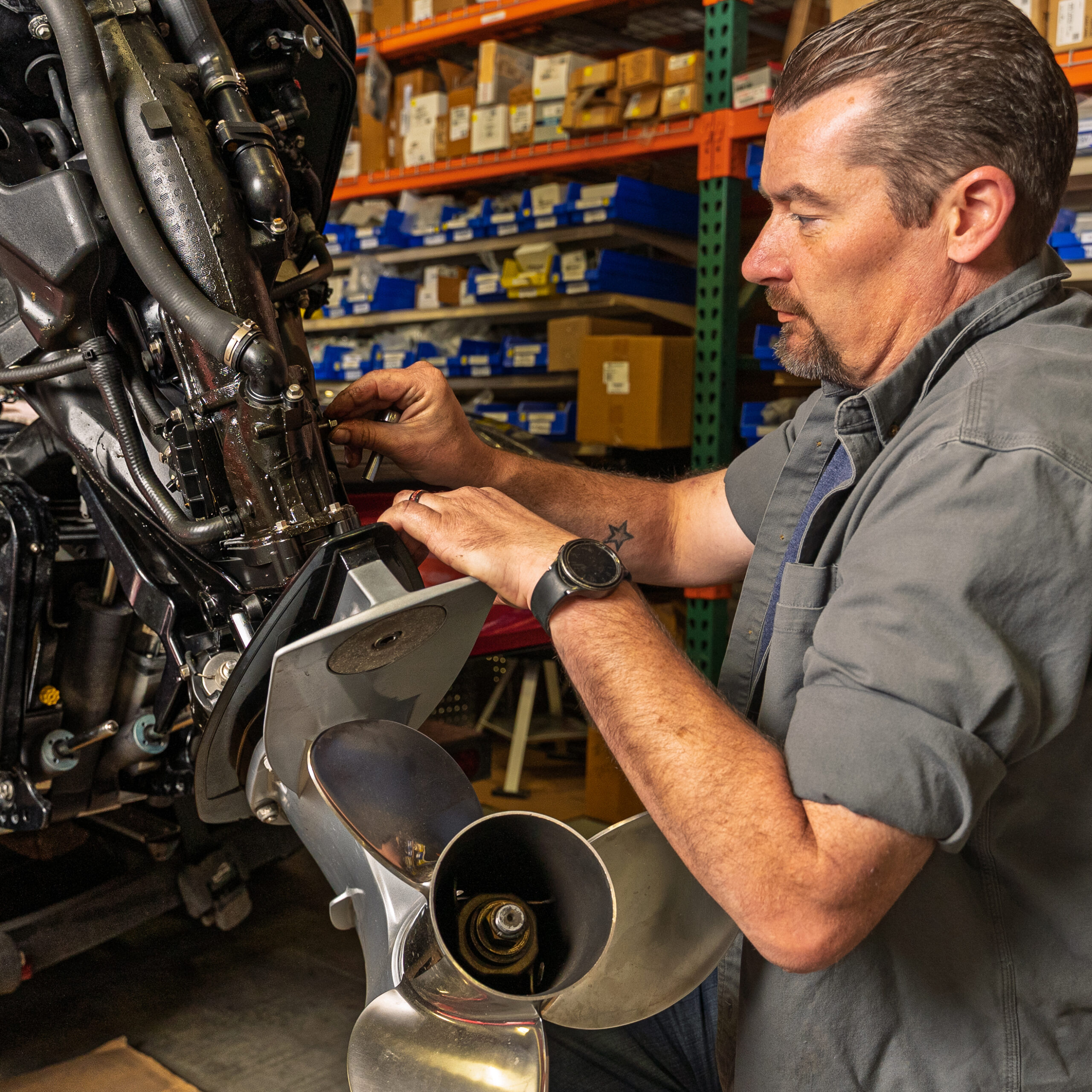 Man repairing a boat motor in workshop