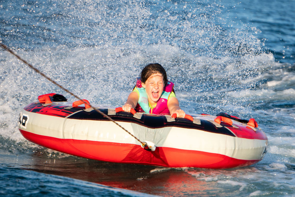 Child tubing on water with splash